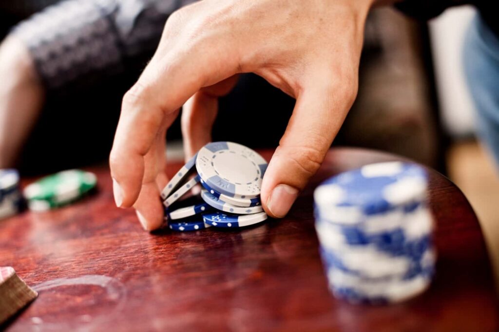 hand-holding-poker-chips-at Castillo Casino